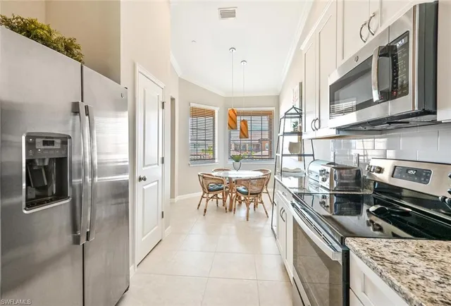 a kitchen with stainless steel appliances granite countertop a refrigerator and a stove top oven