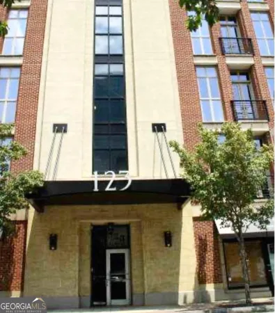 a front view of a building with a tree