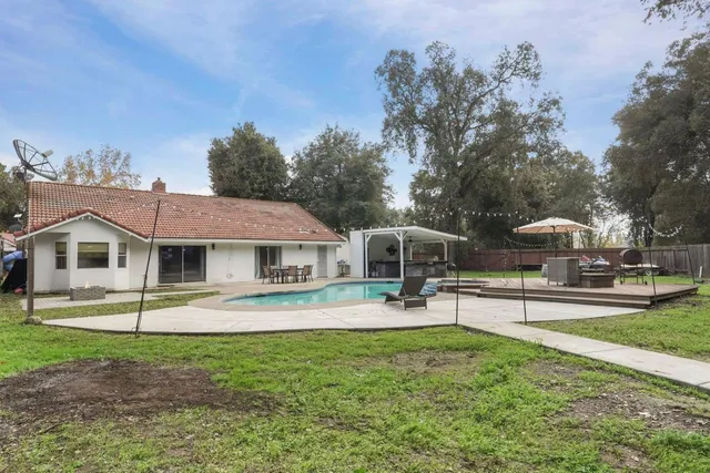 a front view of a house with a garden and trees