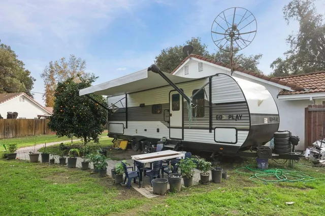 a view of a chair and table in backyard of the house
