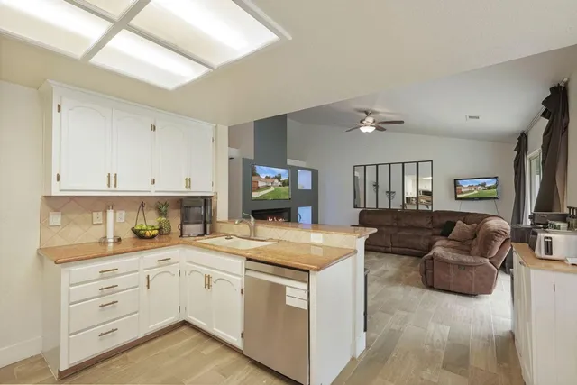 a kitchen with a stove top oven a sink a dining table and chairs