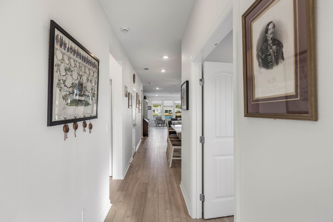 727 Cool Breeze Way Yulee, FL 32097 - Photo 2 of 34 a view of a hallway with wooden floor and a painting on the wall