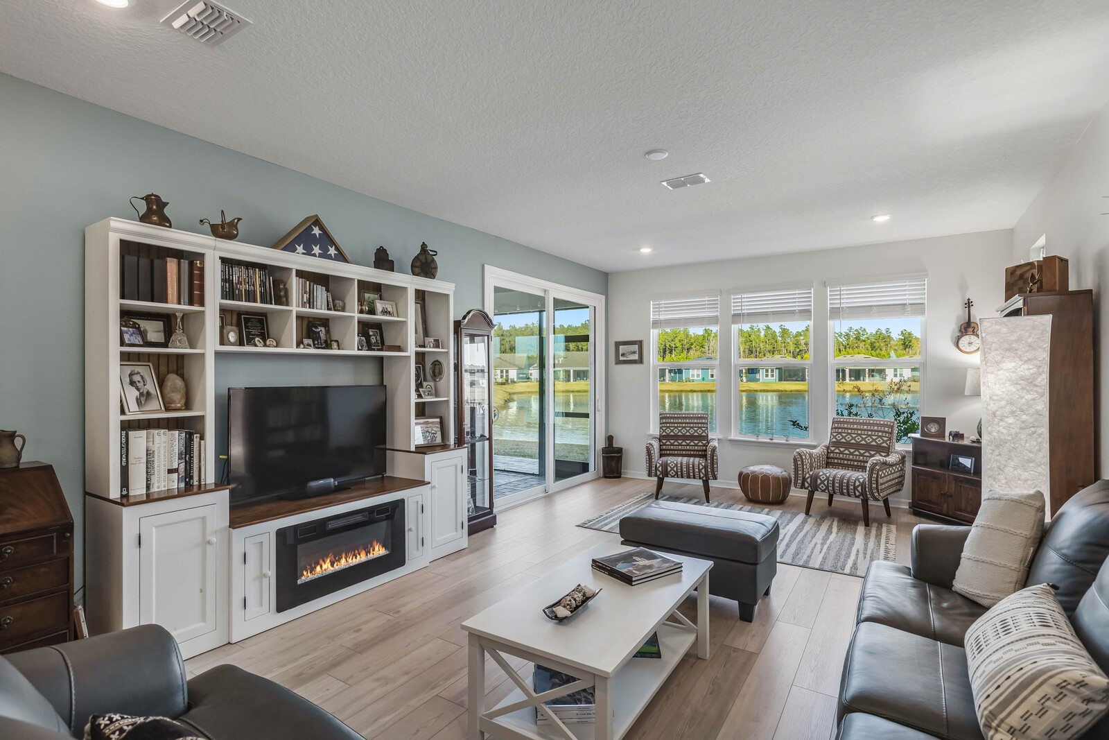 727 Cool Breeze Way Yulee, FL 32097 - Photo 7 of 31 a living room with furniture a flat screen tv and a floor to ceiling window