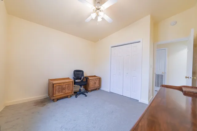 an empty room with a ceiling fan and a window