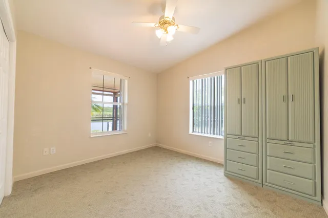 a bedroom with a bed windows and a chandelier