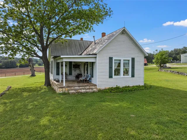 a view of a house with a yard and sitting area