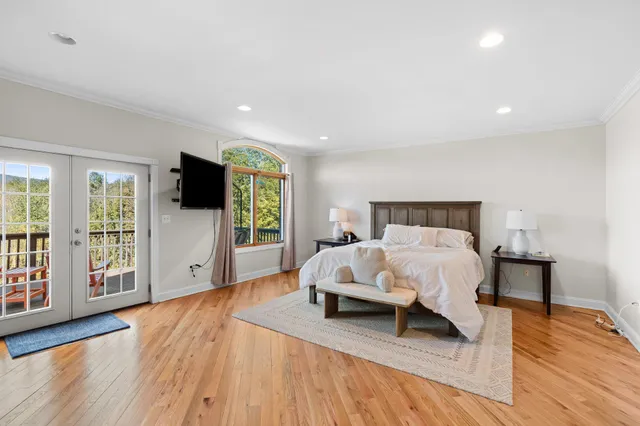 a living room with furniture a flat screen tv and a large window