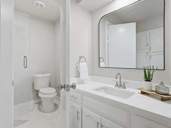 a white toilet sitting next to a shower