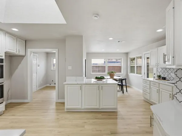 a kitchen with granite countertop white cabinets and stainless steel appliances