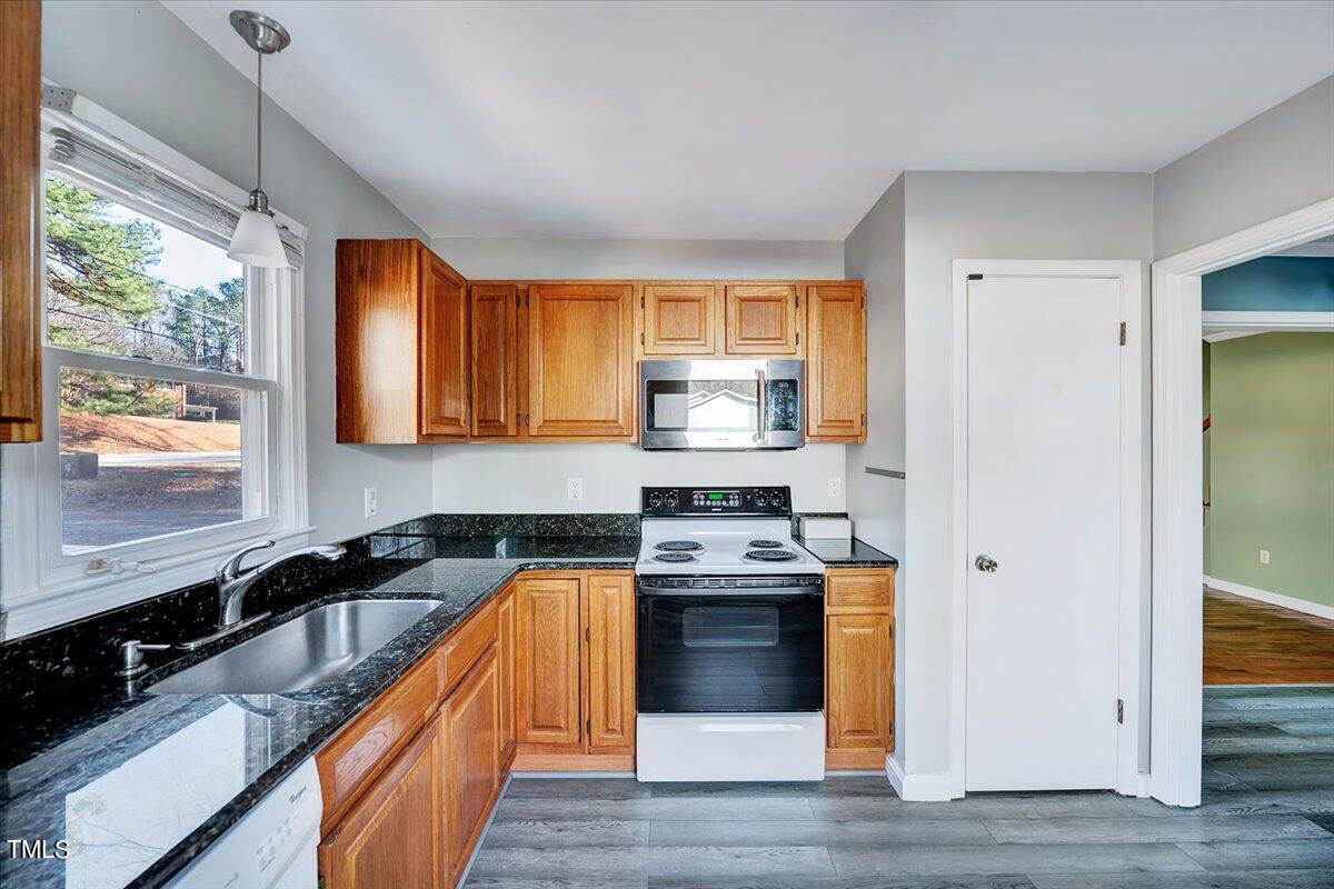 1831 Milan Street Durham, NC 27704 - Photo 11 of 38 a kitchen with stainless steel appliances granite countertop a stove a sink and a refrigerator