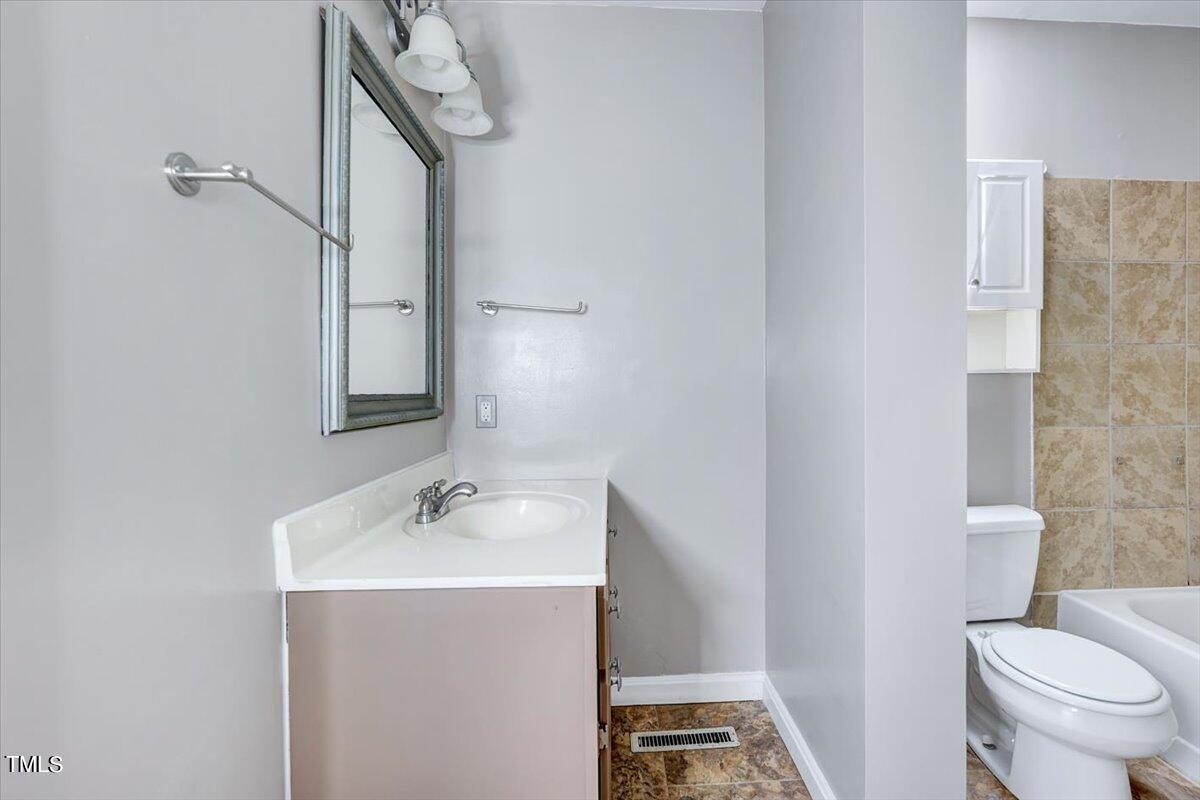 1831 Milan Street Durham, NC 27704 - Photo 17 of 38 a bathroom with a sink a toilet and a mirror