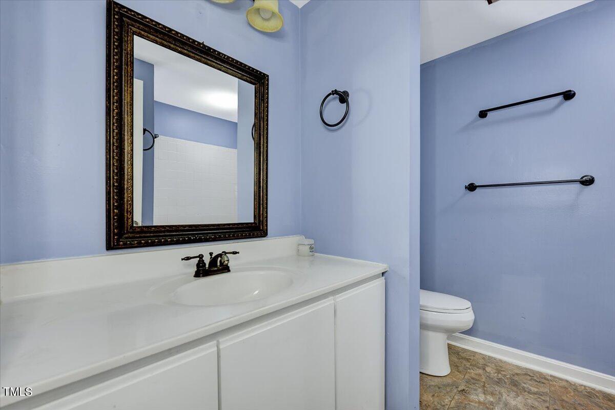 1831 Milan Street Durham, NC 27704 - Photo 23 of 38 a bathroom with a sink a toilet and mirror