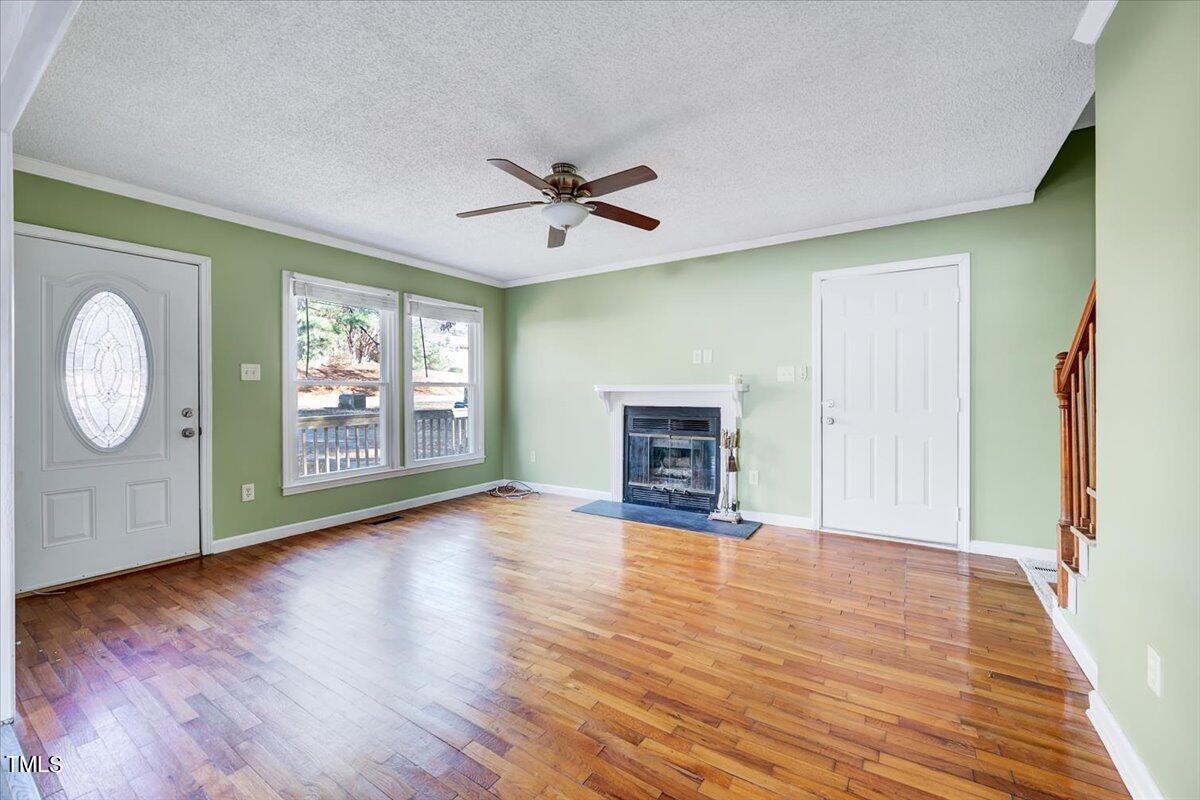 1831 Milan Street Durham, NC 27704 - Photo 6 of 38 an empty room with wooden floor chandelier fan and windows