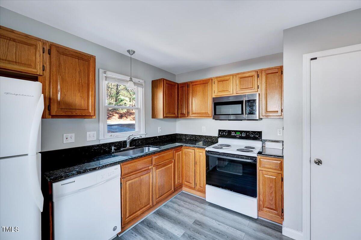1831 Milan Street Durham, NC 27704 - Photo 10 of 38 a kitchen with stainless steel appliances granite countertop a stove a sink and a microwave