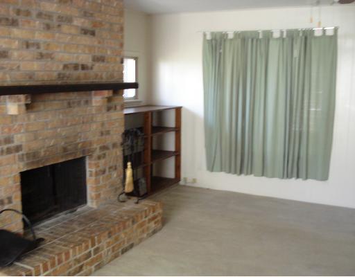 140 Fulton Place Portland, TX 78374 - Photo 6 of 10 a view of an empty room with wooden floor and a fireplace