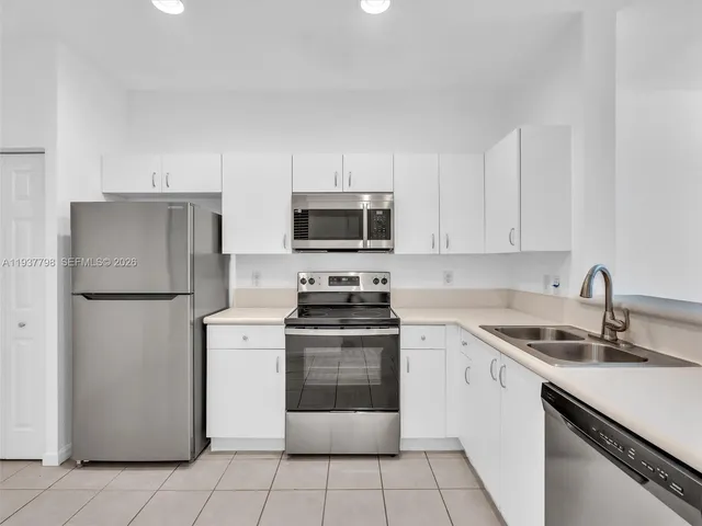 a kitchen with a sink stove and refrigerator