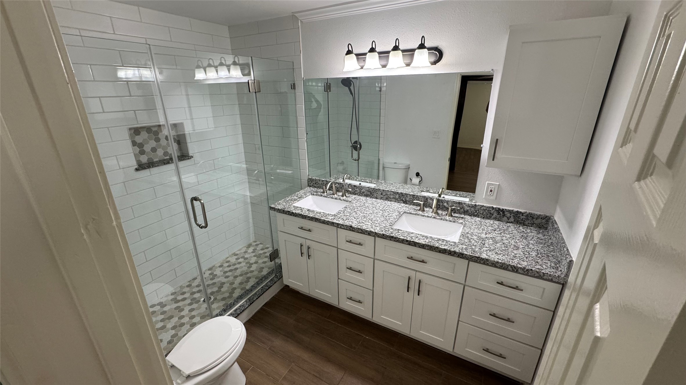 221 Hyta Street Houston, TX 77018 - Photo 15 of 35 a bathroom with a granite countertop sink toilet a mirror a vanity and shower