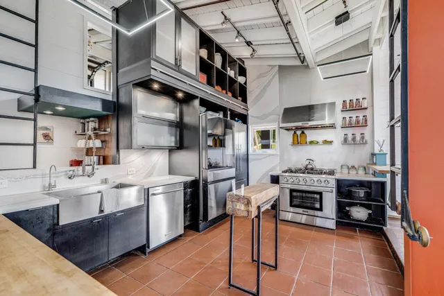a kitchen with stainless steel appliances granite countertop a stove a sink and a refrigerator