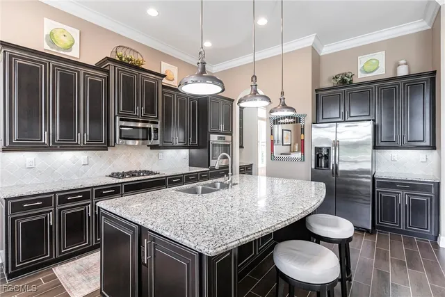 a kitchen with stainless steel appliances granite countertop a sink a stove and a refrigerator
