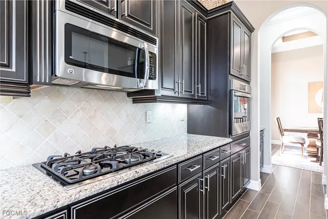 a kitchen with granite countertop a stove and a microwave