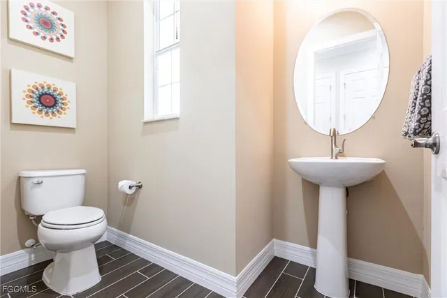 a bathroom with a toilet a sink and a mirror