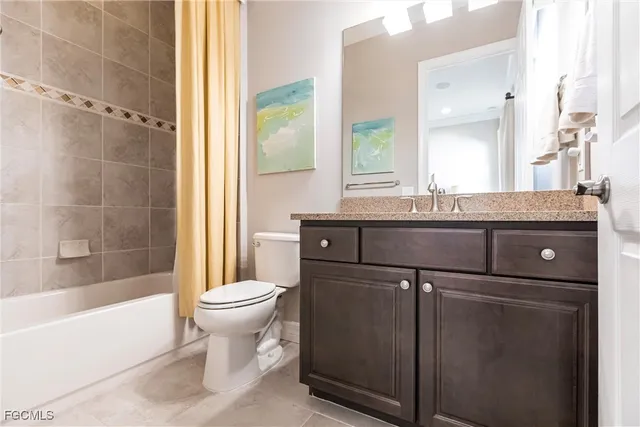 a bathroom with a granite countertop sink mirror vanity and toilet
