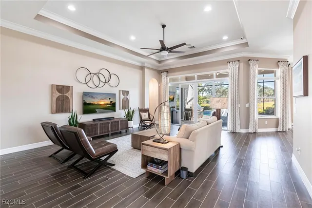 a living room with furniture a flat screen tv and a floor to ceiling window