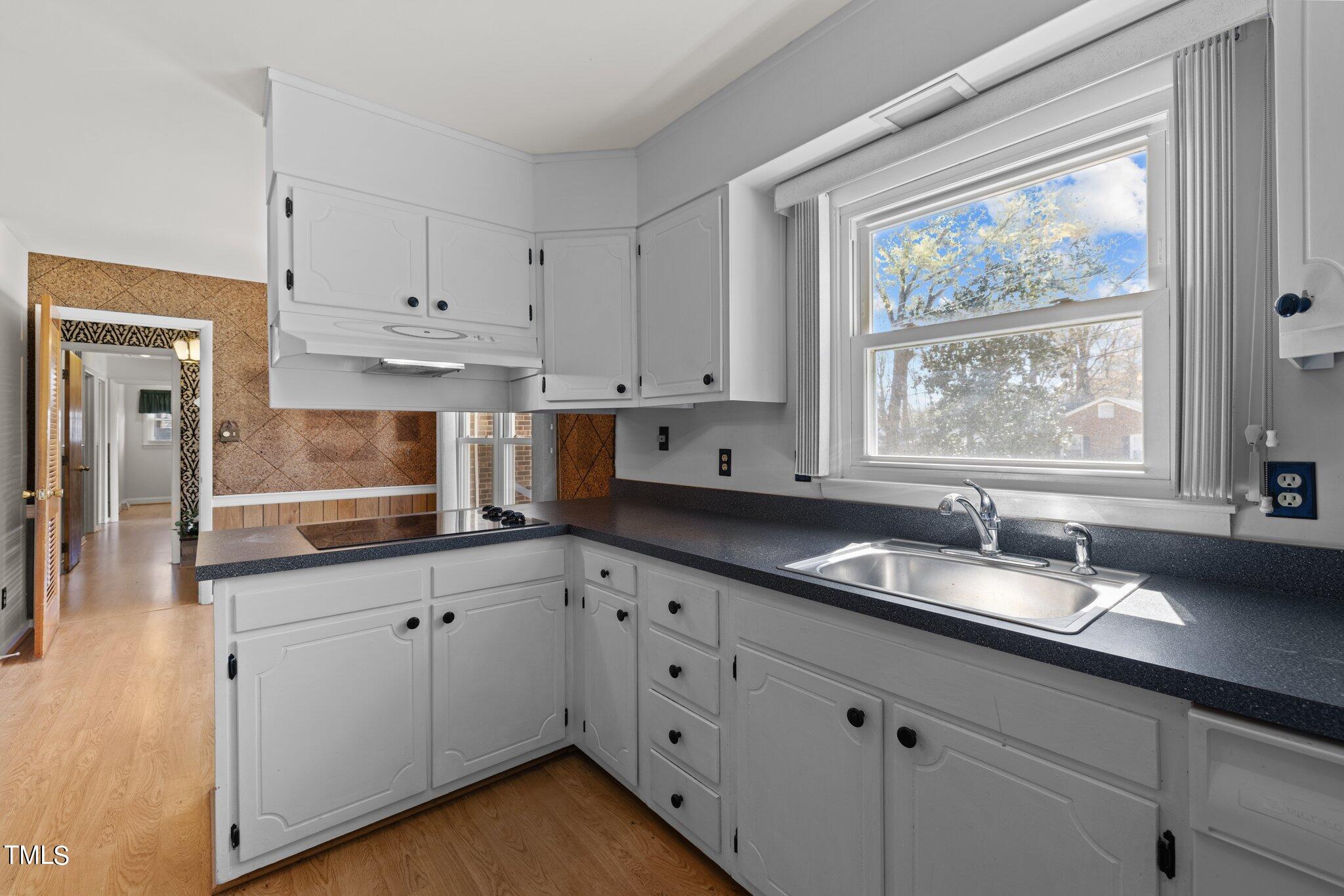 4705 Latimer Road Raleigh, NC 27609 - Photo 10 of 51 a kitchen with granite countertop a sink white cabinets and window