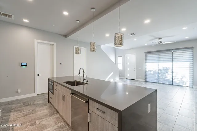 a kitchen with stainless steel appliances granite countertop a sink a stove and a refrigerator