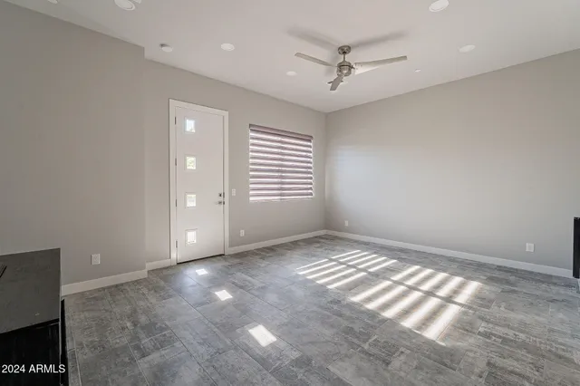 a view of empty room with wooden floor and ceiling fan