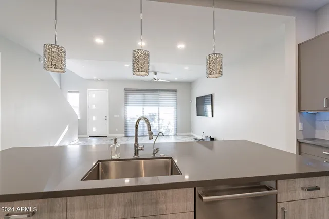 a kitchen with stainless steel appliances granite countertop a sink and a large window