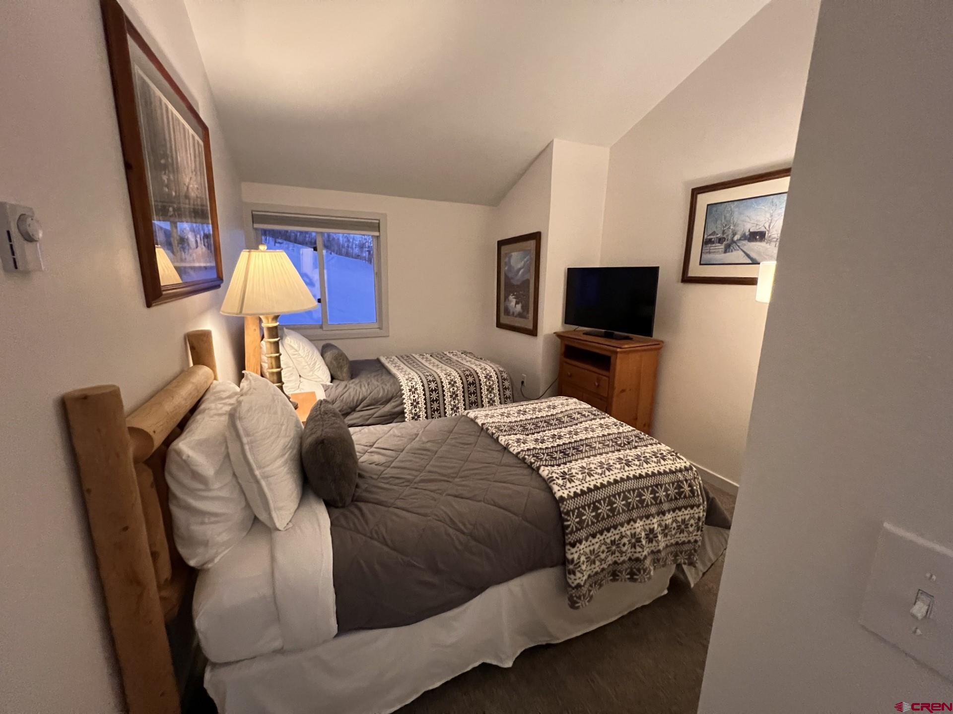 31 Crested Mountain Lane, Unit C2 Crested Butte, CO 81225 - Photo 13 of 25 a bedroom with a bed and wooden floor