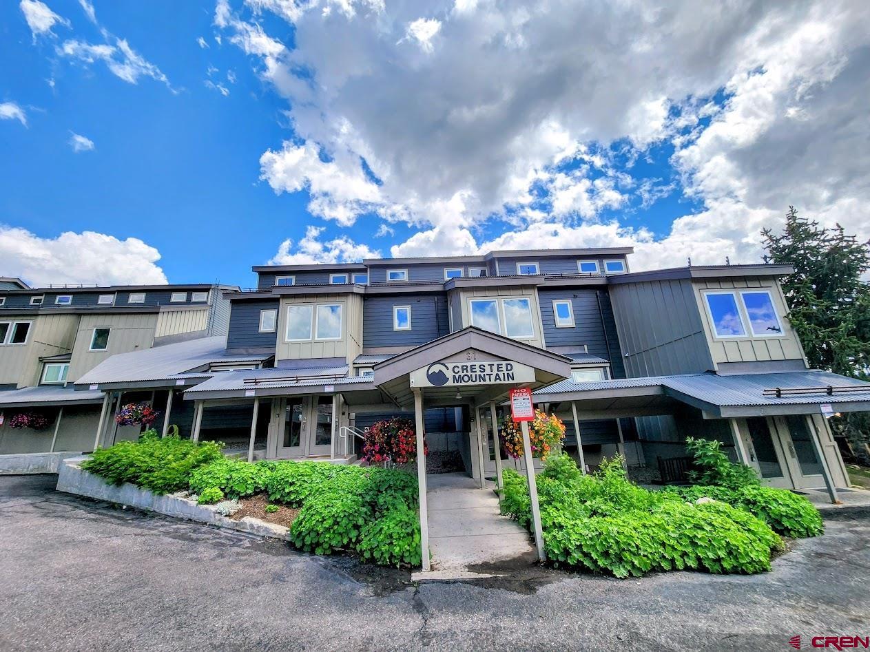31 Crested Mountain Lane, Unit C2 Crested Butte, CO 81225 - Photo 3 of 25 a front view of a multi story residential apartment building with a yard