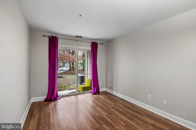 a view of a room with wooden floor and cabinets