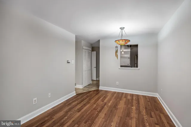 a view of empty room with wooden floor and window