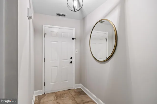 a view of a room with wooden floor and mirror