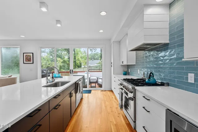 a kitchen with kitchen island granite countertop a sink a counter top space stainless steel appliances and cabinets