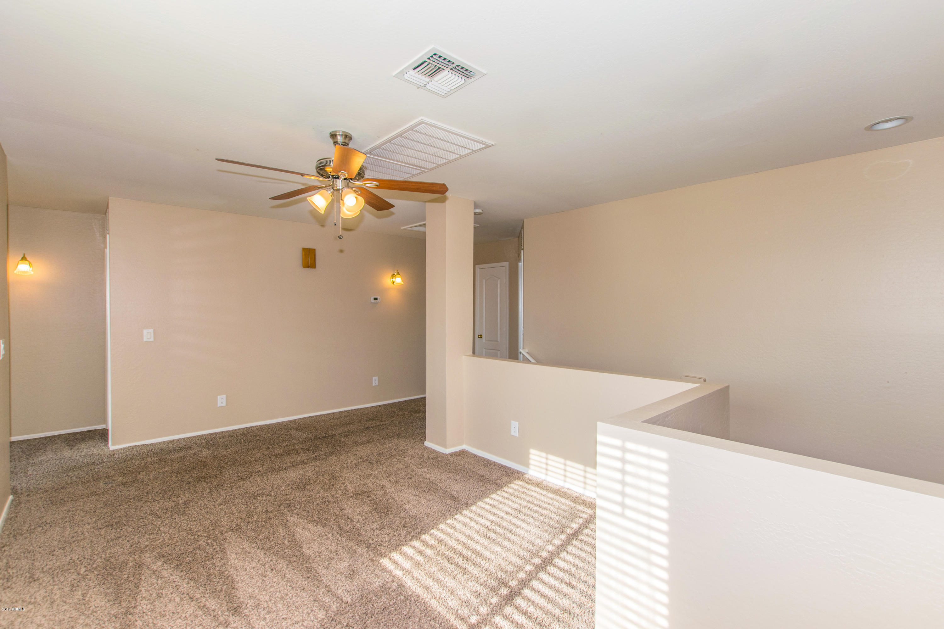 43750 West Magnolia Road Maricopa, AZ 85138 - Photo 12 of 28 a view of a room with a ceiling fan and carpet