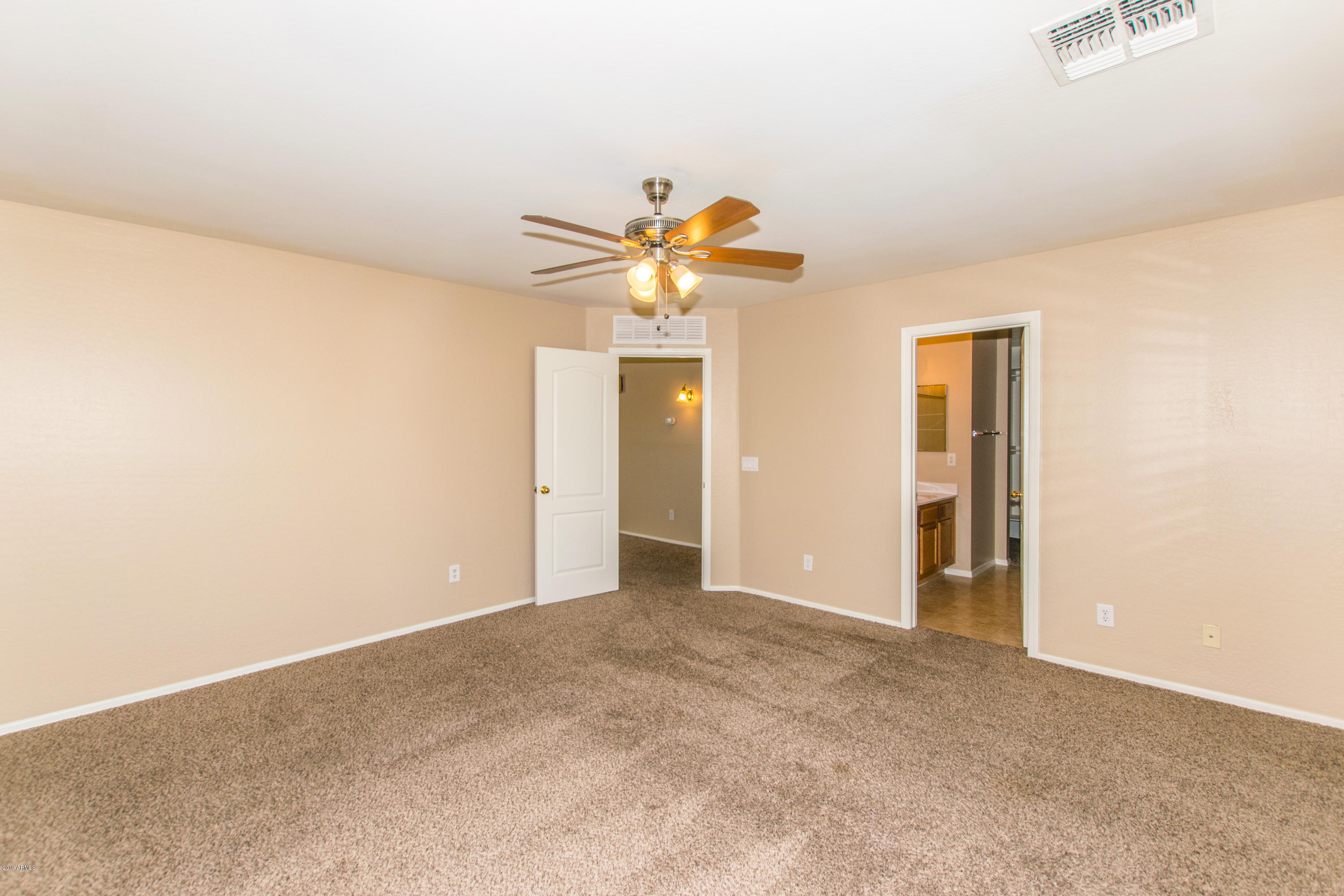 43750 West Magnolia Road Maricopa, AZ 85138 - Photo 14 of 28 an empty room with closet and a chandelier fan