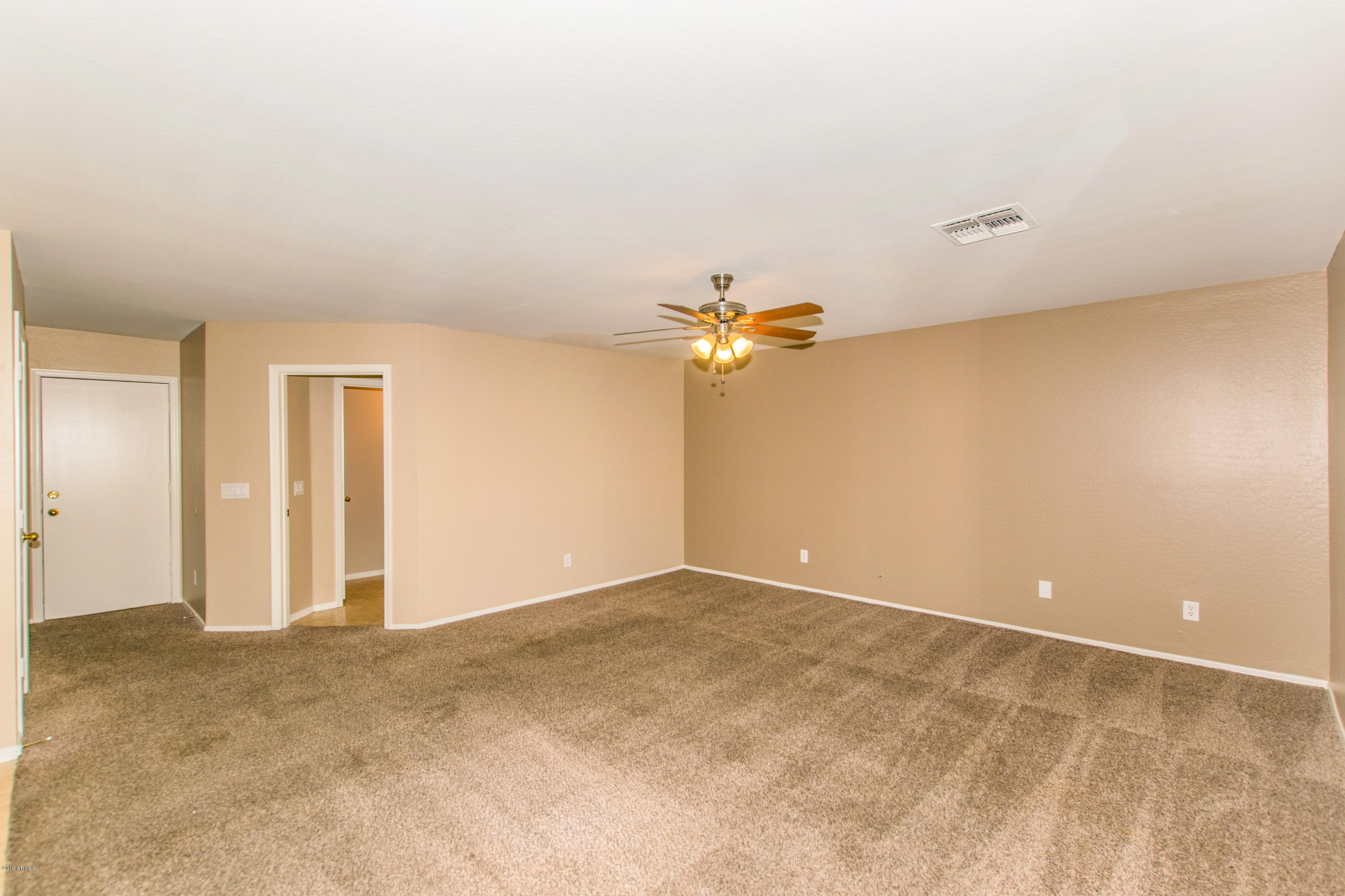 43750 West Magnolia Road Maricopa, AZ 85138 - Photo 4 of 28 an empty room with a chandelier fan