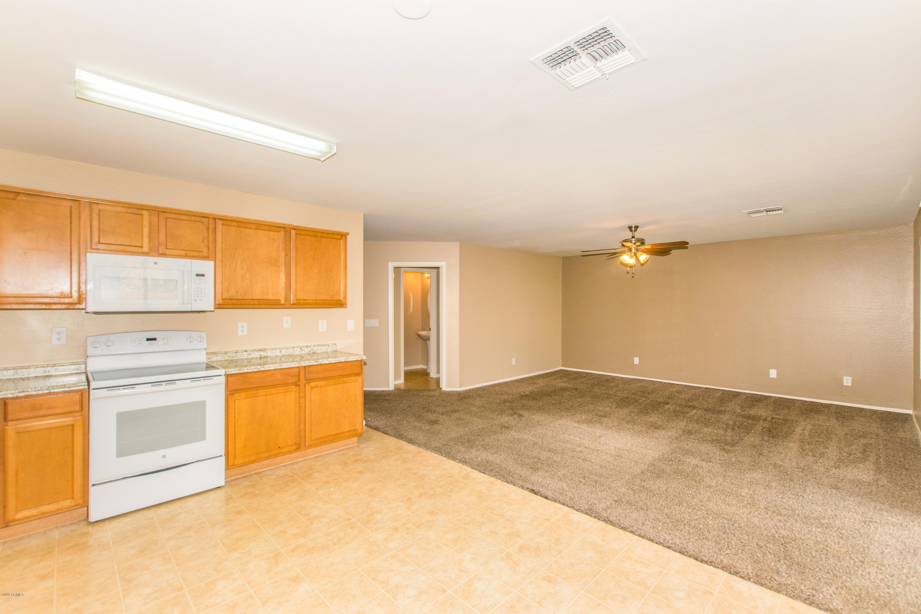 43750 West Magnolia Road Maricopa, AZ 85138 - Photo 9 of 28 a view of a kitchen with a sink and dishwasher with white cabinets