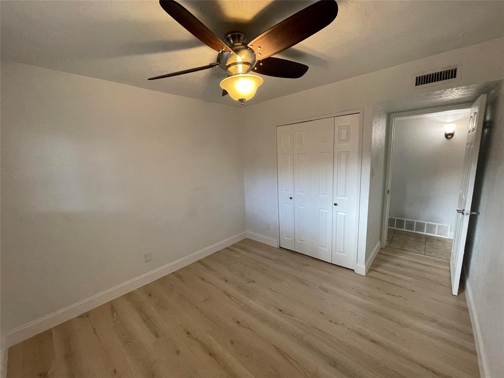 3732 Pinewood Street Bedford, TX 76021 - Photo 14 of 18 an empty room with wooden floor fan and windows