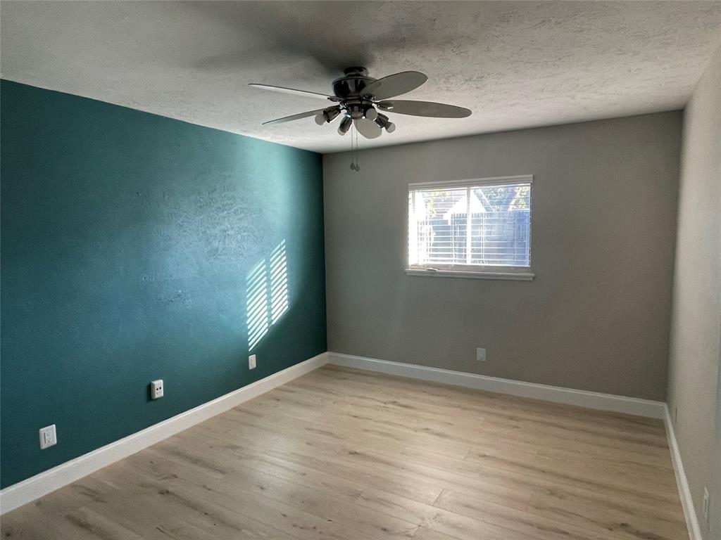 3732 Pinewood Street Bedford, TX 76021 - Photo 16 of 18 an empty room with wooden floor fan and windows
