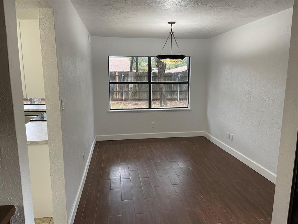 3732 Pinewood Street Bedford, TX 76021 - Photo 6 of 18 an empty room with wooden floor and windows
