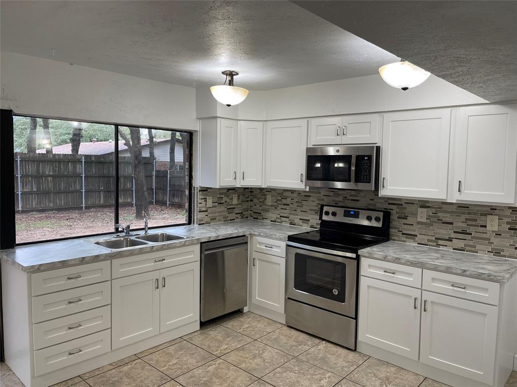 3732 Pinewood Street Bedford, TX 76021 - Photo 7 of 18 a kitchen with a stove microwave and cabinets