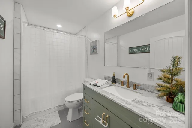 a bathroom with a granite countertop sink a toilet and a mirror