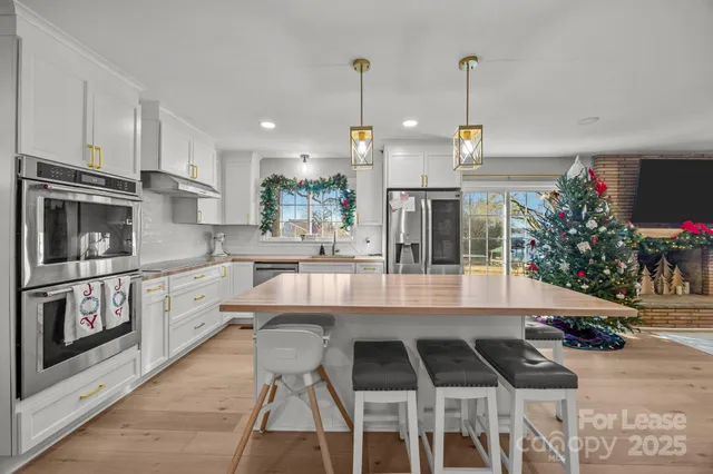 a kitchen with stainless steel appliances granite countertop a stove a sink and a refrigerator