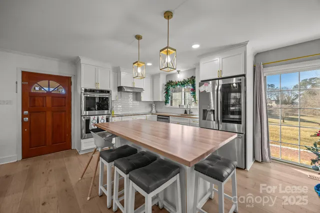 a kitchen with stainless steel appliances granite countertop a sink a refrigerator and a wooden cabinets