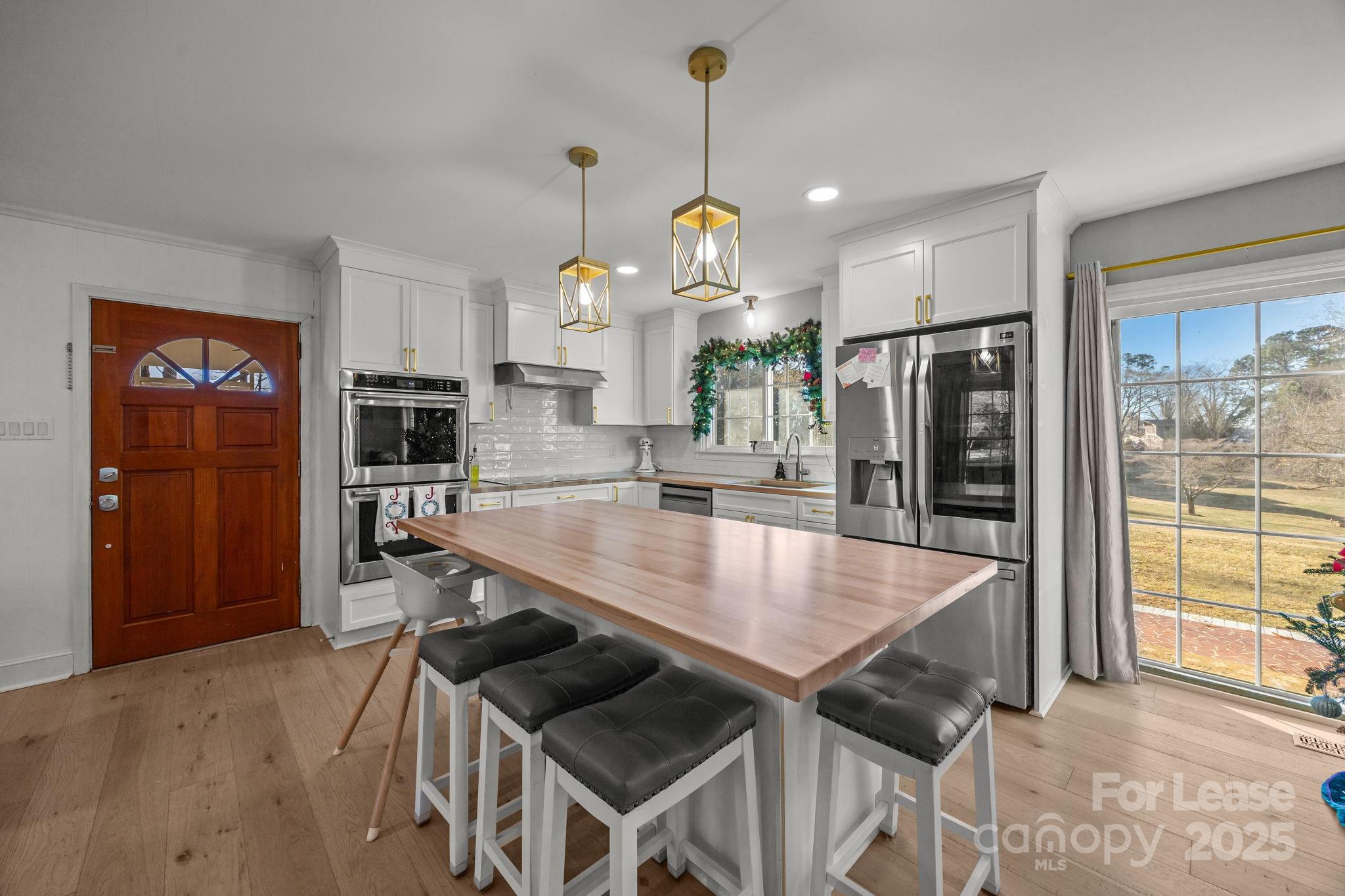 4611 Kiser Island Road Terrell, NC 28682 - Photo 9 of 40 a kitchen with stainless steel appliances granite countertop a sink a refrigerator and a wooden cabinets
