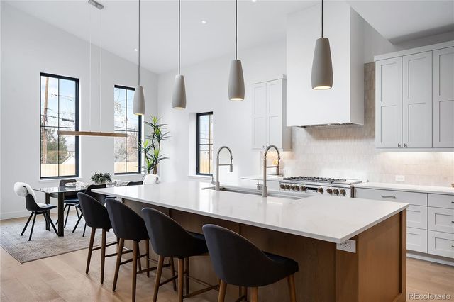 a kitchen with a sink a stove and chairs